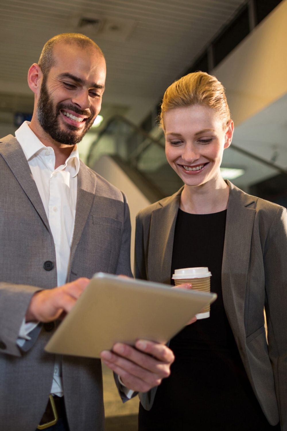 Businesspeople discussing over digital tablet at airport
